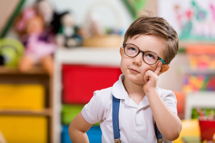 Little boy with glasses planning in classroom.